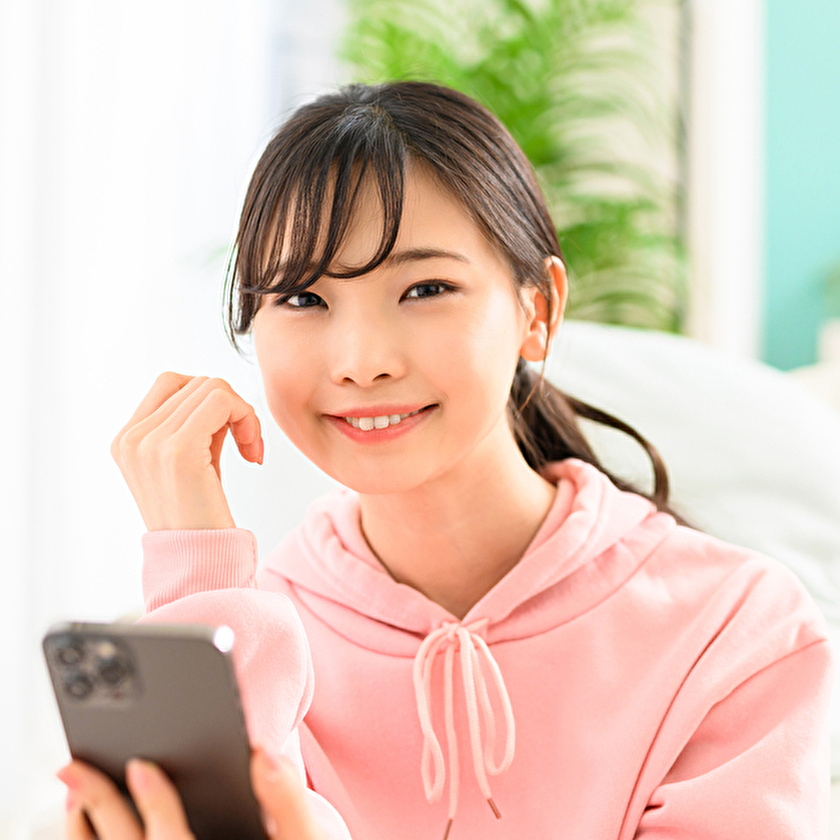 ルームウェアを着てスマホを見る女性